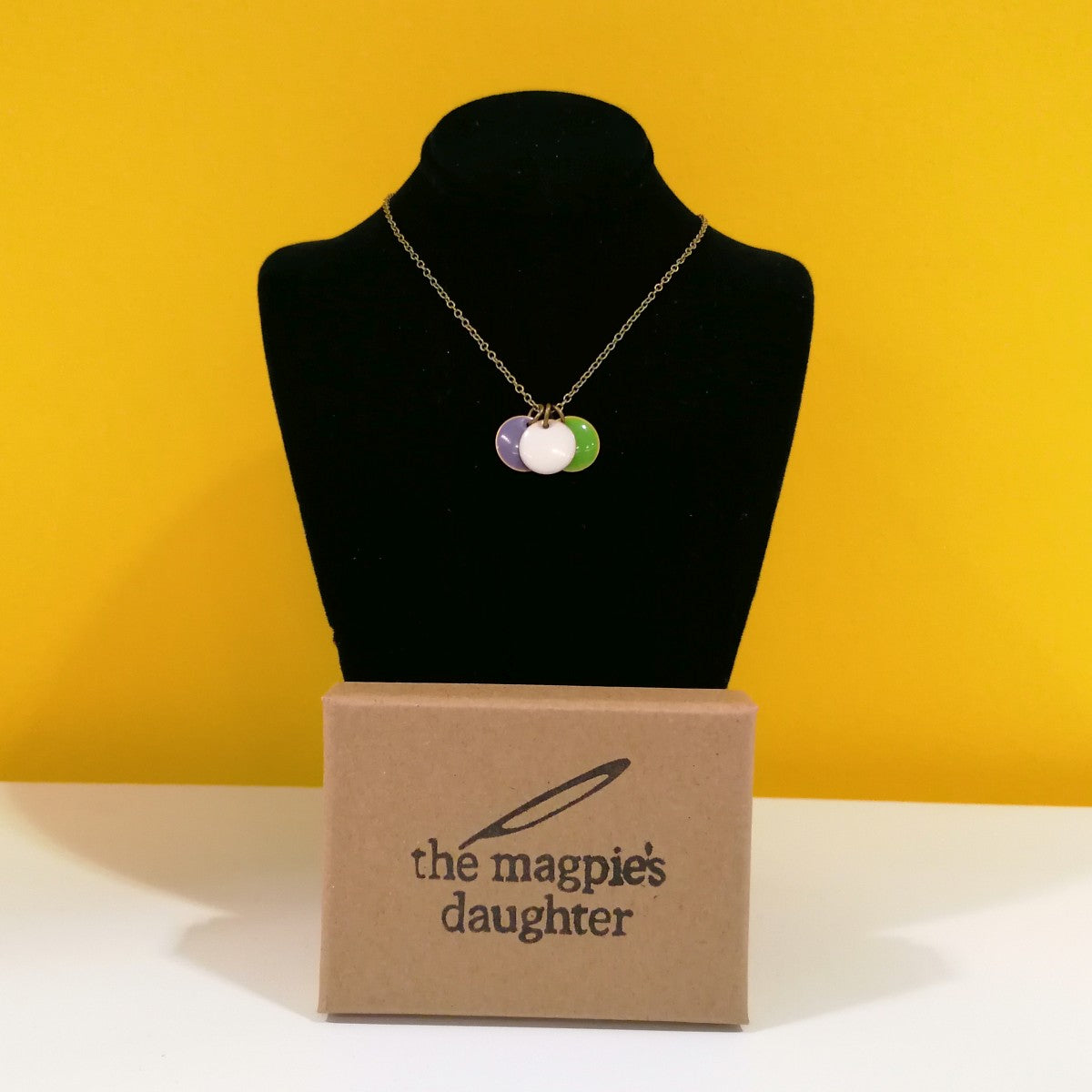 Bespoke suffragette inspired necklace, with three enamel coins in purple, white and green | Image courtesy of People's History Museum shop